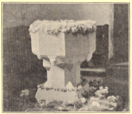 A black and white photograph, by Rev. Hilderic Friend, of a font decorated with flowers, for Easter, Bolton, Cumberland.