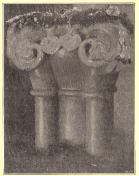 A black and white photograph, by Rev. Hilderic Friend, of a Roman font decorated with flowers, for Easter, Cross Canonby, Cumberland.