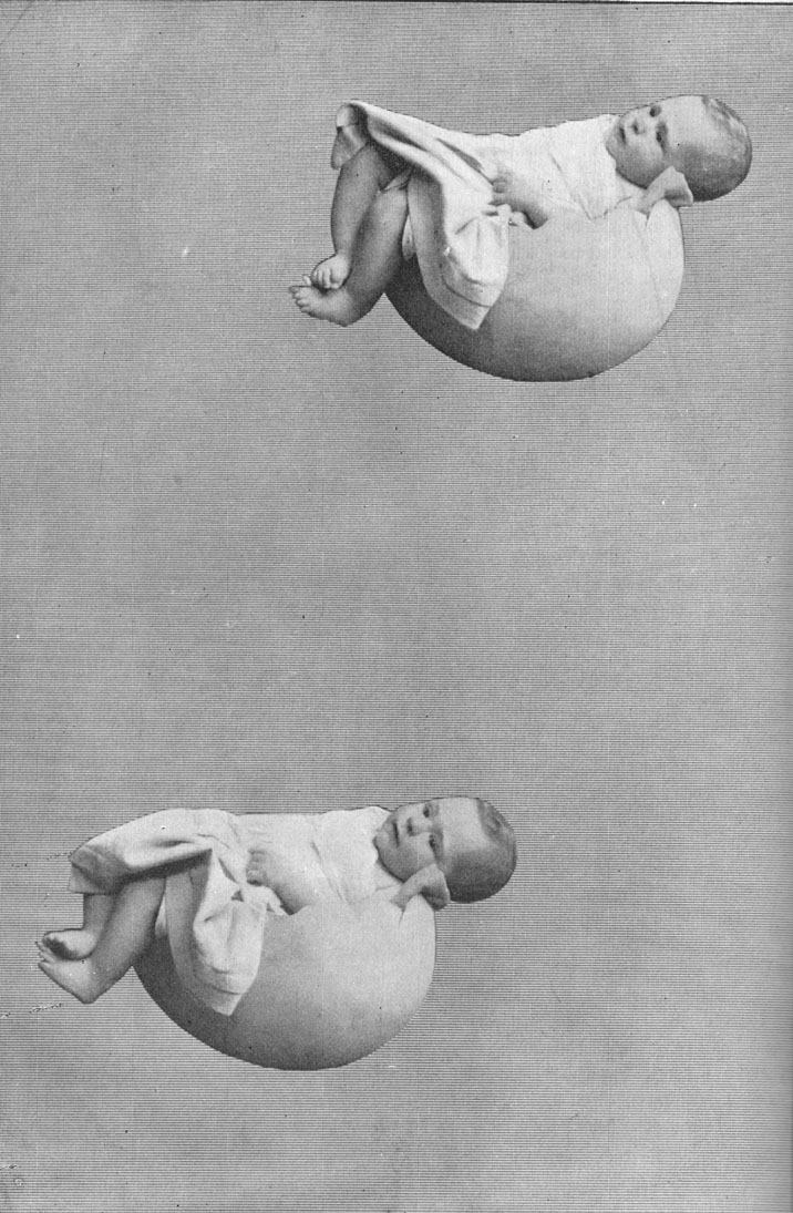 Black and white photograph of two babies each sleeping in half an eggshell suspended in mid-air. Early example of tricks and illusions of photography.