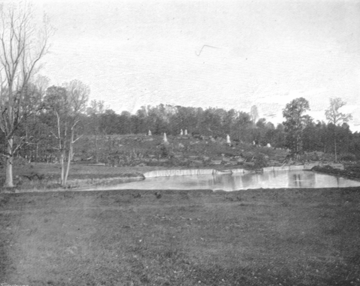 Black and white photograph of Round Top, showing a flat field, with some standing water and a small rise in the land beyond.